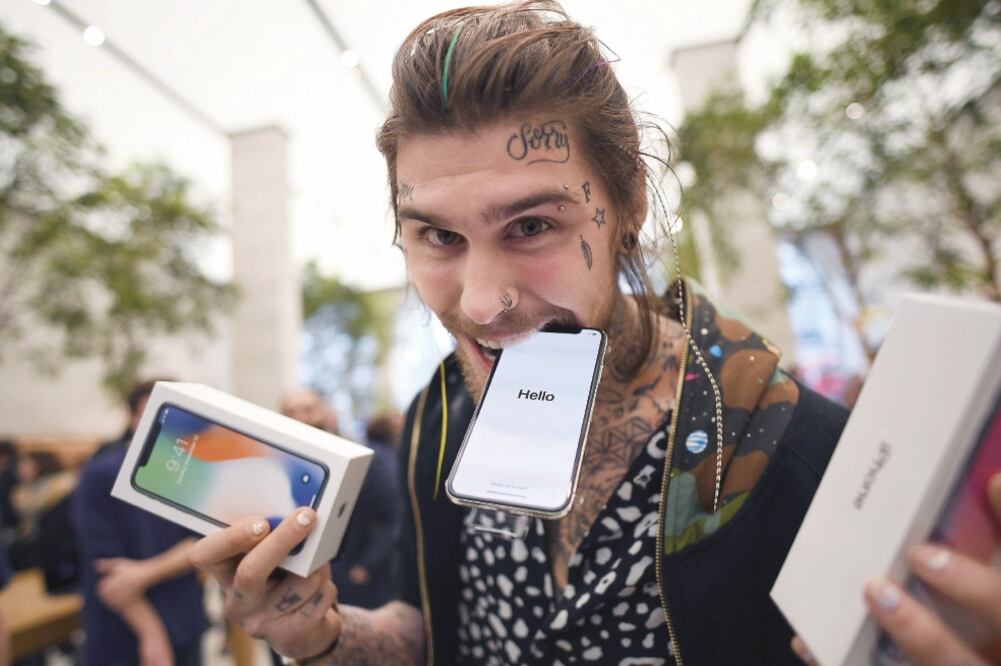 Un joven muestra su nuevo iPhone X frente a una tienda Apple luego de comprarlo durante su lanzamiento en Londres, Reino Unido. (STEFAN ROUSSEAU.XINHUA)