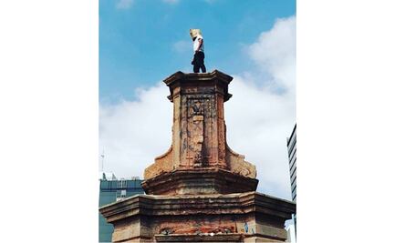 Artista hace performance en el pedestal del Monumento a Colón en Reforma como protesta