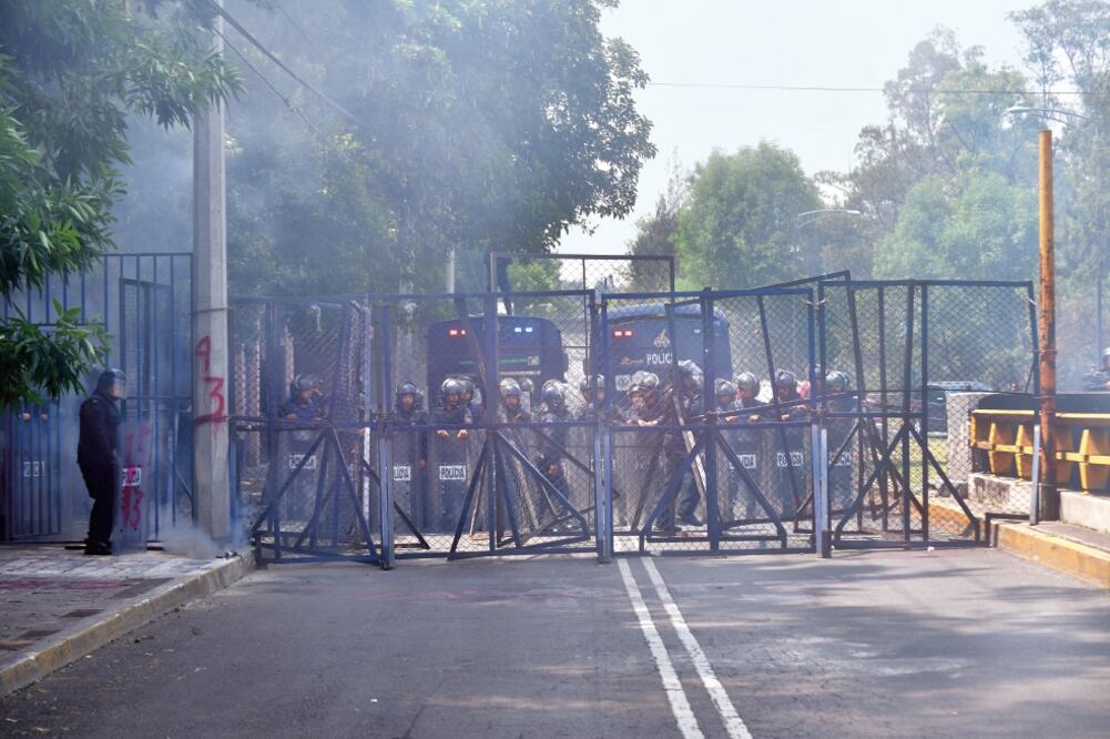 En el inicio de la glorieta de Chivatito, más de 30 granaderos de la Secretaría de Seguridad Pública de la Ciudad de México les cerraron el paso con vallas a los manifestantes, quienes respondieron aventándoles petardos. Foto: HUGO GARCÍA. EL UNIVERSAL