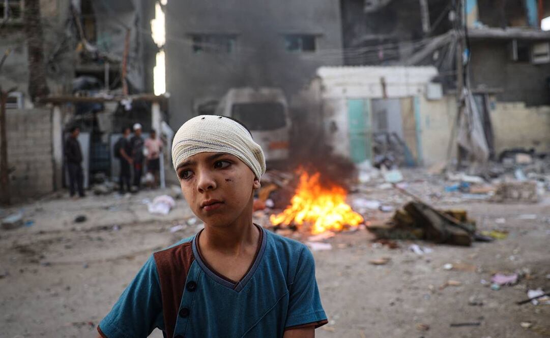 Un niño palestino herido se encuentra junto a los escombros de una casa familiar que fue alcanzada durante la noche durante un bombardeo israelí en el barrio Tal al-Sultan de Rafah. Foto: AFP