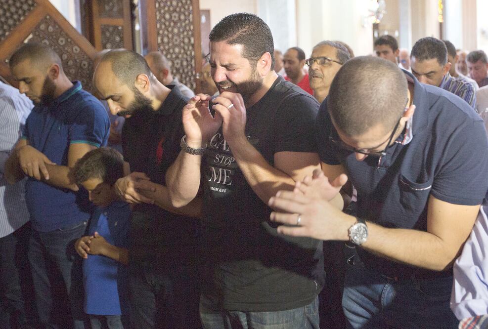 Osman Abu Laban, director de cine egipcio (primero a la der.), quien perdió a cuatro familiares en el avionazo, durante una misa por los fallecidos en El Cairo (AMR NABIL. AP)