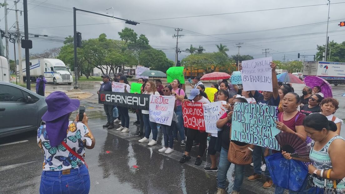 Sin importar la lluvia, trabajadores despedidos de una maquiladora, exigieron su liquidación. Foto Especial