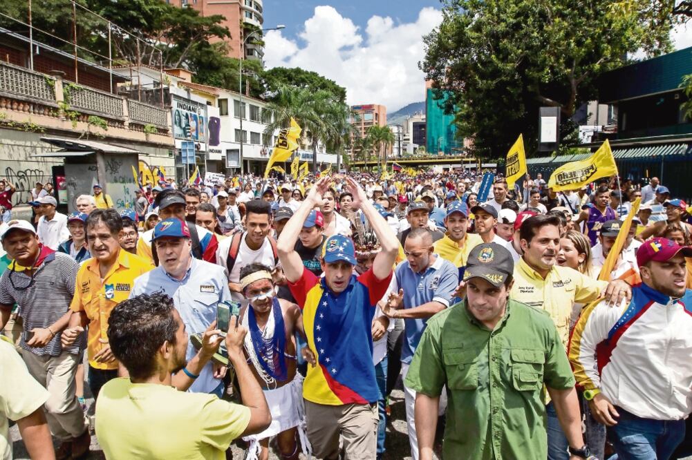 El líder opositor Henrique Capriles (centro) encabeza a uno de los contingentes que participaron ayer en la marcha denominada “Toma de Caracas” para exigir a las autoridades que aceleren la agenda hacia el referéndum revocatorio (MIGUEL GUTIÉRREZ. EFE)