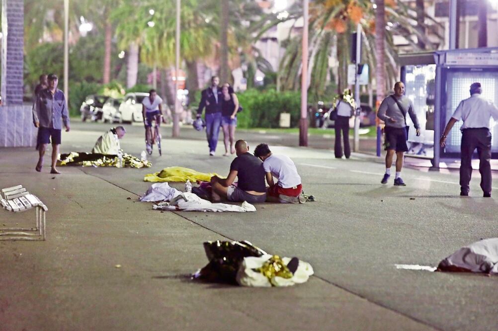 Después del ataque, algunos de los sobrevivientes permanecieron al lado de los cuerpos de las víctimas. Cientos de personas se habían reunido a la orilla del mar para ver los fuegos artificiales por el Día de la Bastilla (ERIC GAILLARD. REUTERS)