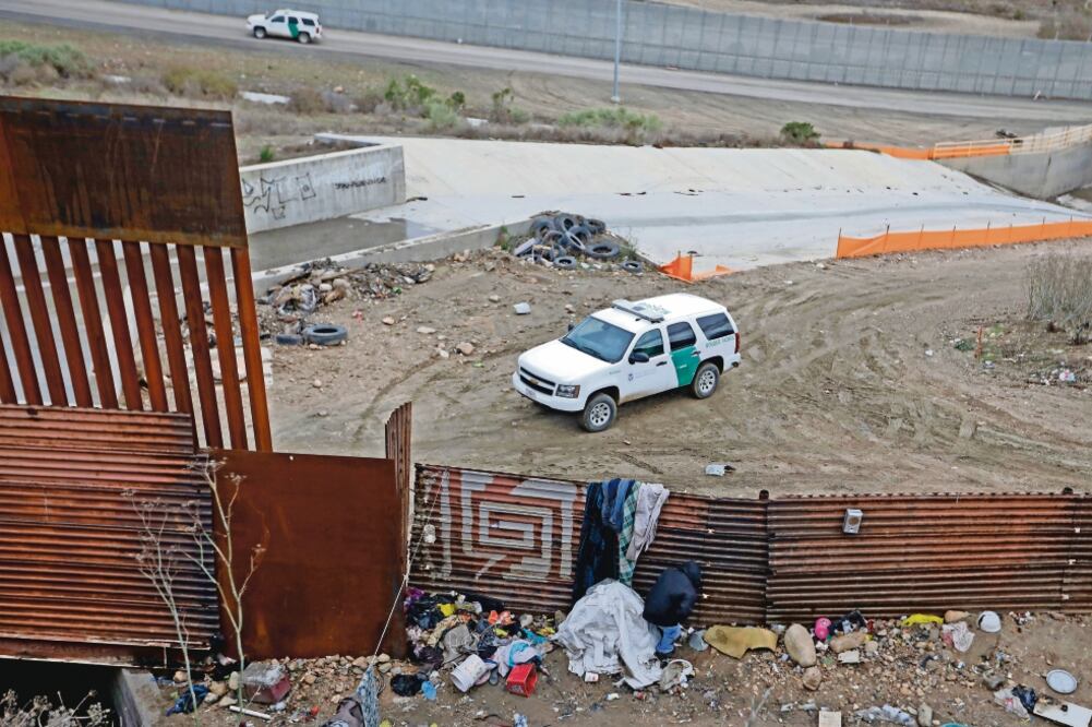 En San Ysidro, California. Un hombre intenta cruzar la frontera de México con EU, mientras la Patrulla Fronteriza espera. (REBECCA BLACKWELL. AP)