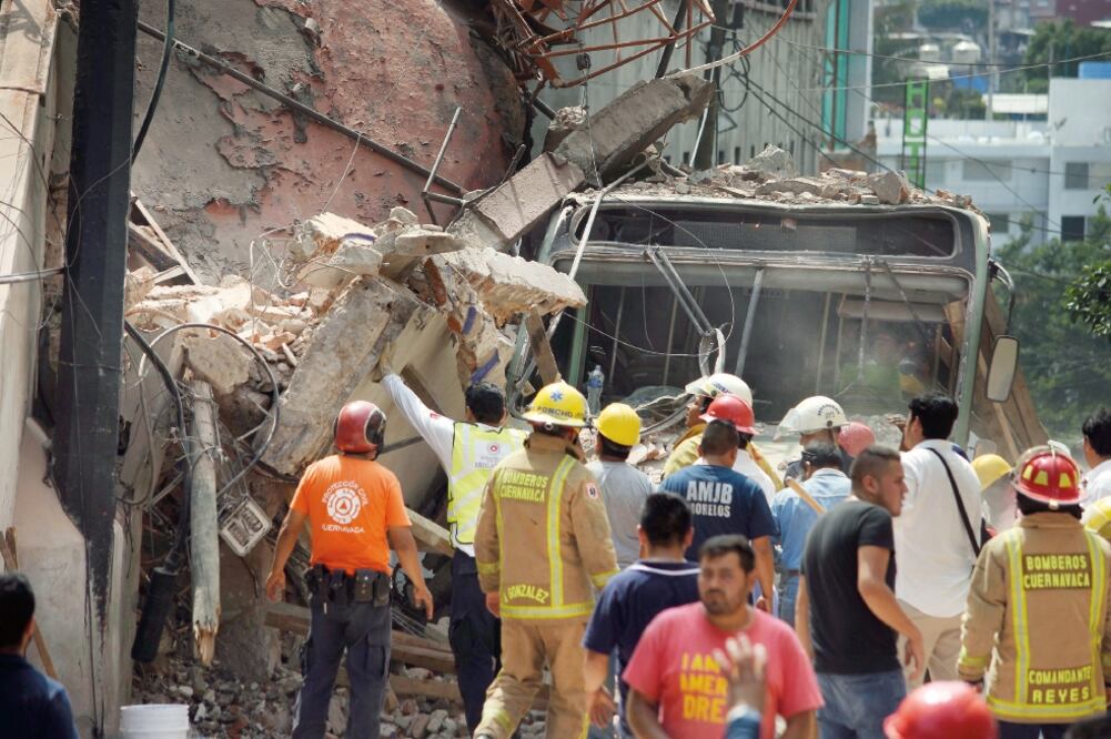Grandes bloques de concreto y una antena de transmisión sepultaron medio microbús; los bomberos ayudaron a los 25 pasajeros a salir (TONY RIVERA. EL UNIVERSAL)