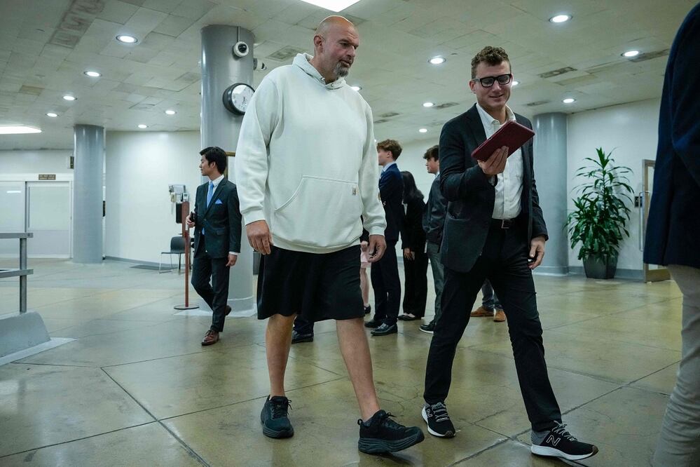 El senador estadounidense John Fetterman, de shorts y sudadera, camina por los pasillos del Capitolio. AFP