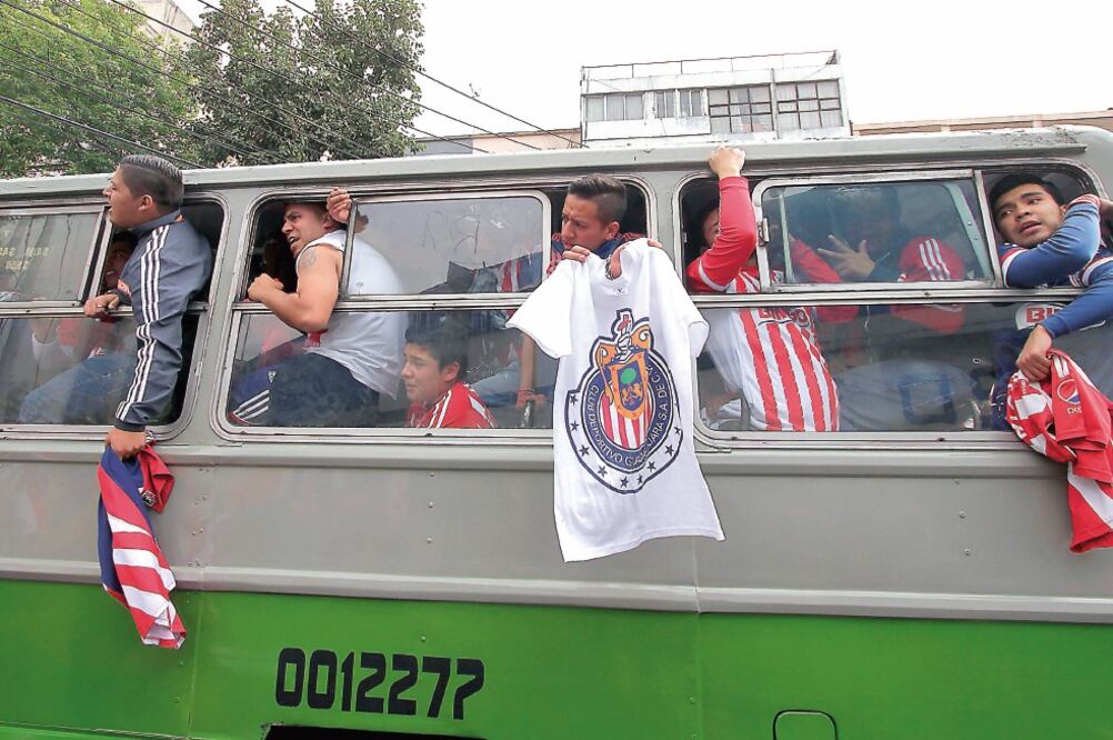 Centenares de seguidores del Rebaño colmaron microbueses en una marabunta rojiblanca hacia el estadio (CARLOS MEJÍA. EL UNIVERSAL)