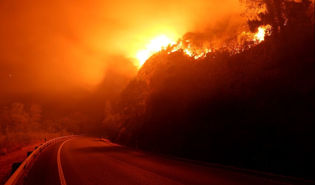 Imagen de un incendio forestal junto a una carretera en Aguasmestas, una parroquia del municipio de Quiroga, en la provincia de Lugo. Foto: EFE