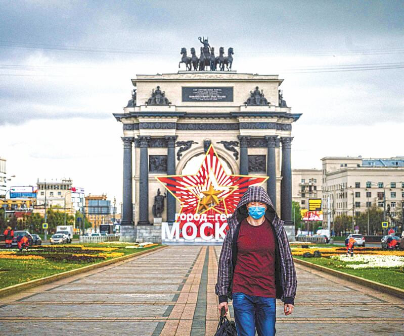 Monumento. Protegido contra el virus, un hombre camina en Moscú en una instalación dedicada a la victoria sobre los nazis. Foto: DIMITAR DILKOFF. AFP