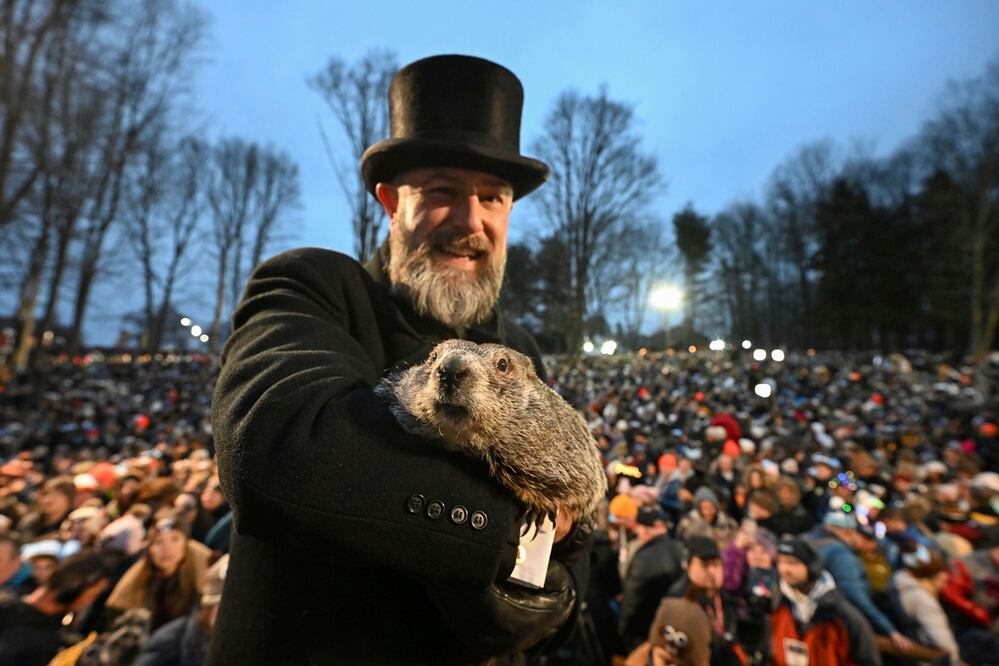 A.J. Dereume, del Club de la Marmota, sostiene a Punxsutawney Phil, la marmota que pronostica el clima, durante la celebración número 138 del Día de la Marmota en Gobbler's Knob en Punxsutawney, Pennsylvania. Foto: AP