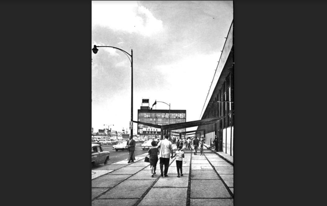 Una familia camina por la acera de la terminal del nuevo aeropuerto capitalino en los años sesenta. Al fondo se encuentra el edificio sede de las oficinas administrativas del aeropuerto; en el letrero se aprecian los nombres de las aerolíneas SEASA, Servicios Aéreos Especiales, S.A. y Aerovías Vega. Texto: Víctor Hugo Gutiérrez González Imagen: Col. Villasana-Torres