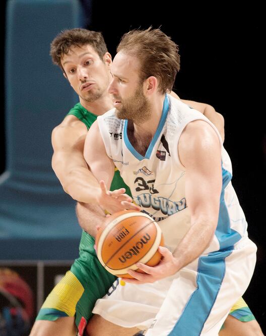 Kiril Waschmann (frente) intenta librar la marca del brasileño Rafael Mineiro; los uruguayos dieron la primera sorpresa (EDUARDO VERDUGO.AP)