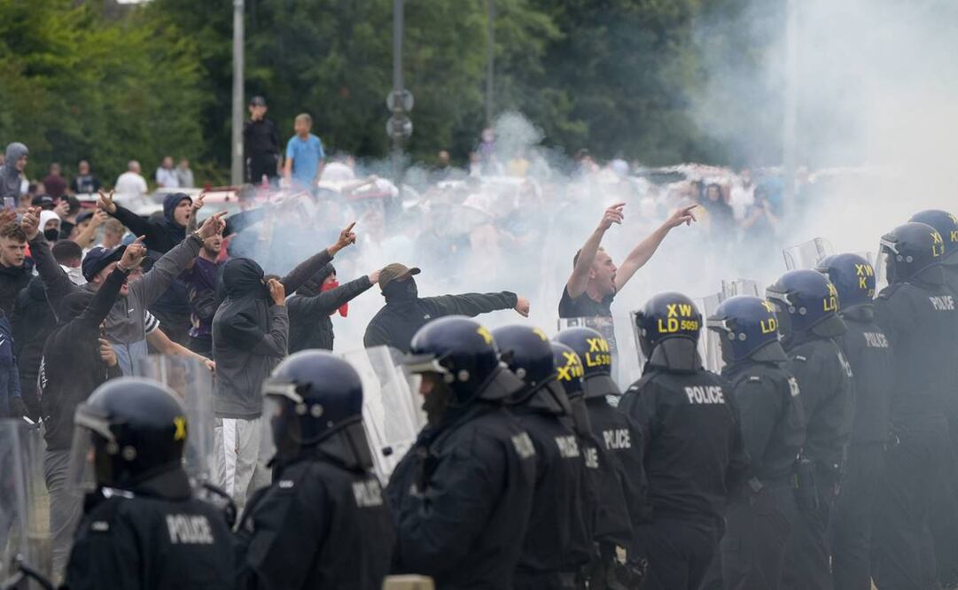 Oficiales de policía se enfrentan a manifestantes durante una manifestación contra la inmigración. Foto: AP