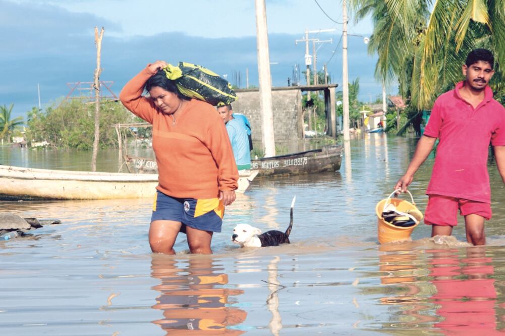 La población comenzó a desplazarse en busca de alimentos, caminando en calles inundadas luego del paso del huracán Max en Tecomate-Pesquería, municipio de San Marcos, Guerrero. (FRANCISCA MEZA. EFE)