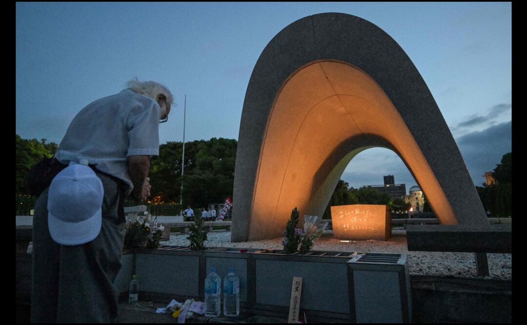 Los visitantes rezan por las víctimas de la bomba atómica frente al cenotafio conmemorativo en el Parque Memorial de la Paz, antes de la ceremonia conmemorativa del 80.º aniversario del primer ataque con bomba atómica del mundo, en la ciudad de Hiroshima, en la madrugada del 6 de agosto de 2025. (Foto de Richard BROOKS y Richard A. Brooks / AFP)