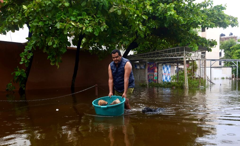 Ante la inundación de su departamento en la Unidad Habitacional "Vicente Guerrero 2000", Mario Fierro evacuó a sus mascotas "Pulga", "Piojo", "Pelusa" y "La Negra" en una tina que desplazó sobre las calles anegadas del puerto de Acapulco. Foto: Valente Rosas/EL UNIVERSAL
