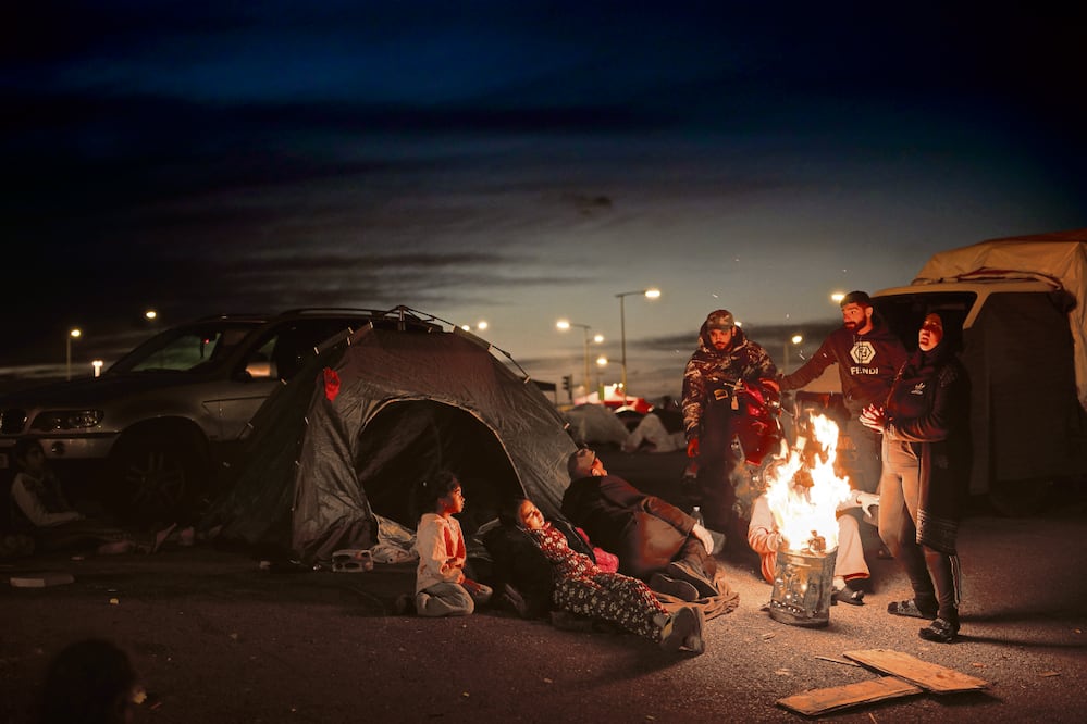 Integrantes de una familia que huyó de los ataques israelíes en el sur del Líbano, alrededor de una hoguera frente a una tienda de campaña utilizada como refugio en Beirut. Foto: Emilio Morenatti / AP