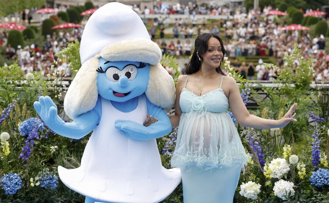 Rihanna posa con una persona disfrazada de Pitufina para los fotógrafos a su llegada al estreno mundial de la película "Los Pitufos". Foto: AP Photo/Omar Havana.