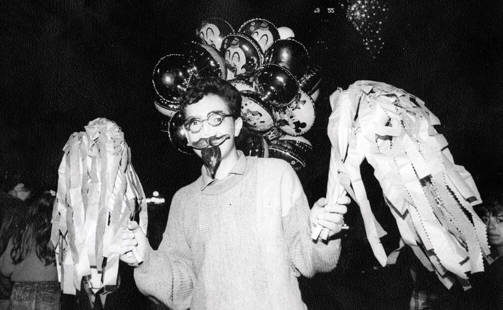Vendedor ambulante que ofrecía bigotes, lentes y cornetas con volantes tricolores, 1989. El comercio actual incluye orejas iluminadas por LED, pollitos con adornos mexicanos o peluches AMLitos. Foto: Manuel Navarrete/Archivo EL UNIVERSAL.