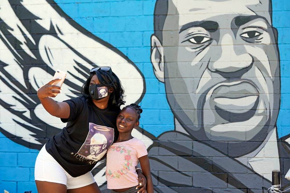Margaret Williams se saca un selfie junto a su hija Nala frente a un mural de George Floyd en el barrio de Houston donde se crió Floyd. Foto del 7 de junio del 2020. (AP Photo/David J. Phillip)
