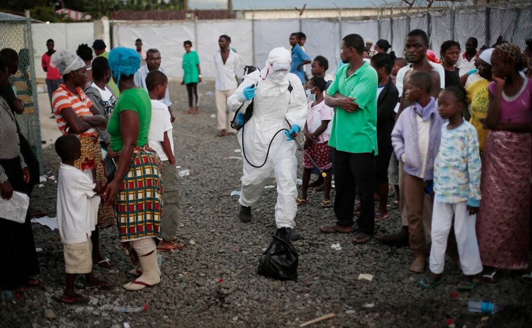 Un trabajador médico rocía a las personas que son dadas de alta del centro de tratamiento del ébola Island Clinic en Monrovia. Foto: AP