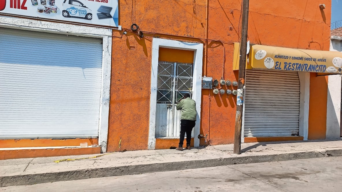 En el acceso a la vecindad algunas personas que caminan por la calle se asoman por las rendijas de la puerta de acceso. Cámaras de video grabaron que elementos de la Guardia Nacional entraron previo a los crímenes Foto: Xóchitl Álvarez EL UNIVERSAL