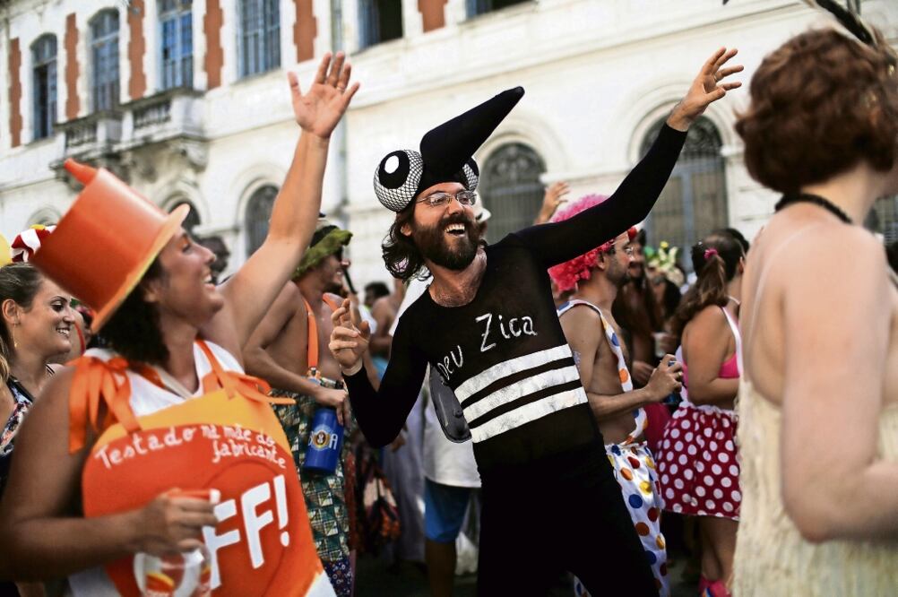 Juerguistas en el Carnaval en Río de Janeiro marcharon ayer disfrazados como el mosquito que transmite el virus del zika y como un repelente de insectos (PILAR OLIVARES. REUTERS)