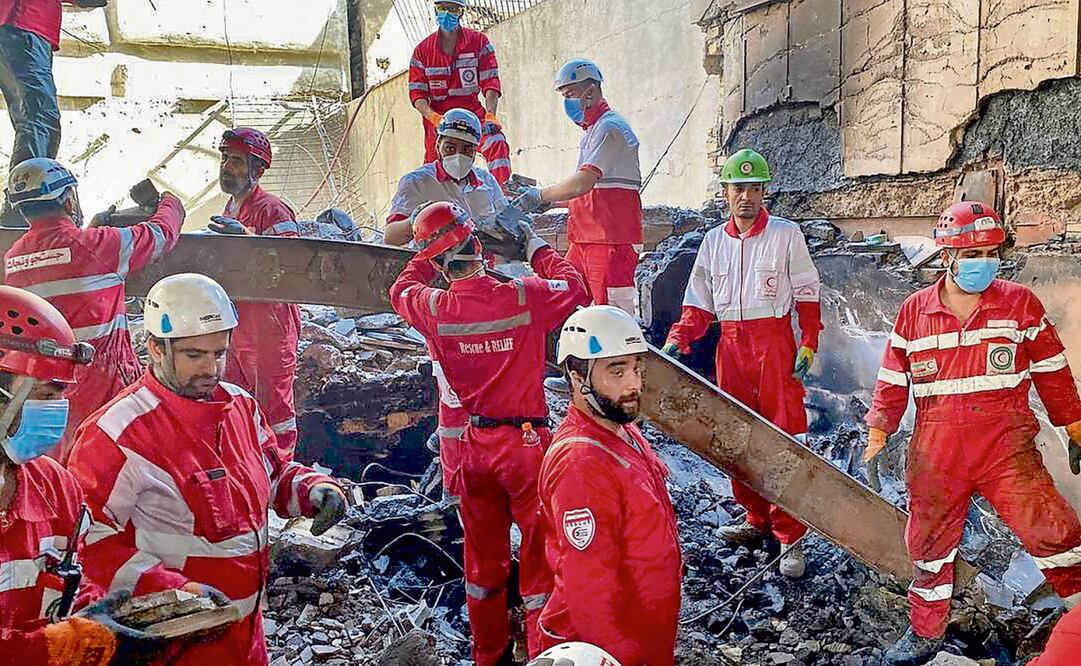 Integrantes de la Media Luna Roja Iraní, al buscar supervivientes entre los escombros de un edificio en Teherán. Foto: AFP