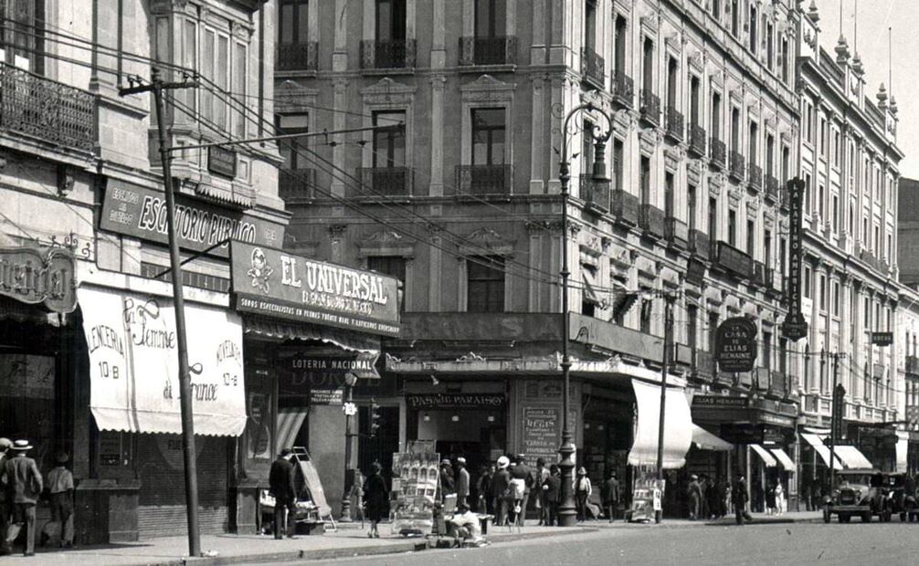 La esquina de Madero y San Juan de Letrán, hoy el Eje Central, a inicios de los años treinta. Del lado izquierdo está la antigua casa de la familia Escandón, ocupada por locales comerciales; hoy en su lugar se encuentra el Edificio Guardiola. Detrás están la sede de la aseguradora La Latinoamericana, donde ahora se ubica la torre del mismo nombre, y el Edificio Rule, que aún existe. Imagen: Colección Villasana.