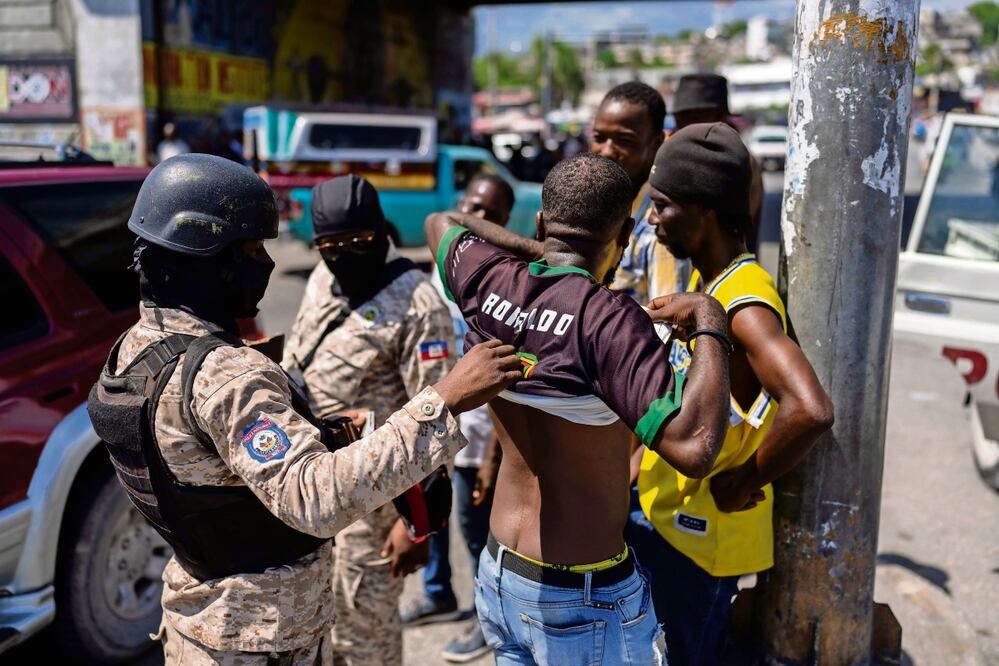 Un policía revisa a un haitiano en busca de armas, en Puerto Príncipe. Foto: Ramón Espinosa AP