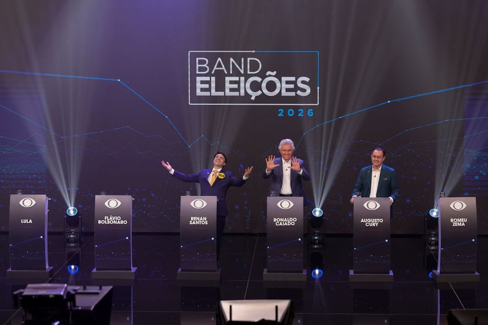 Tres de los candidatos a la presidencia de Brasil: Renan Santos, Ronaldo Caiado y Augusto Cury posan junto a los púlpitos de los candidatos ausentes Luiz Inácio Lula da Silva, Flavio Bolsonaro, y Romeu Zema este domingo, en el primer debate de cara a las elecciones presidenciales de Brasil. (23/08/26) Foto: EFE