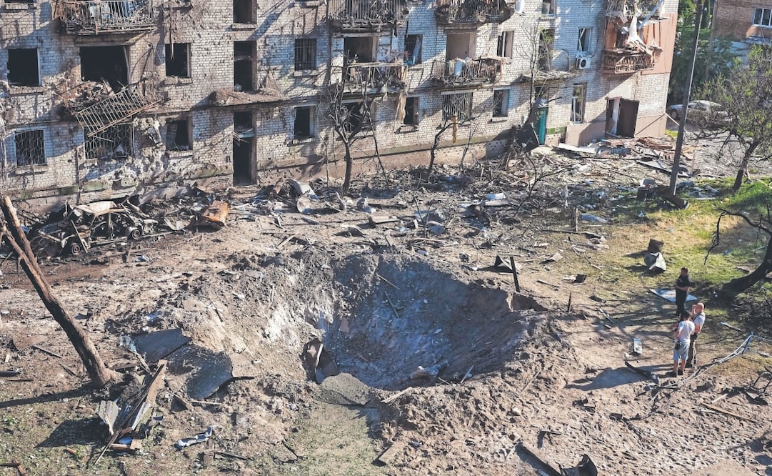Testigos en el lugar donde impactó un misil ruso contra un edificio residencial en Kiev. Foto: Efrem Lukatsky. AP