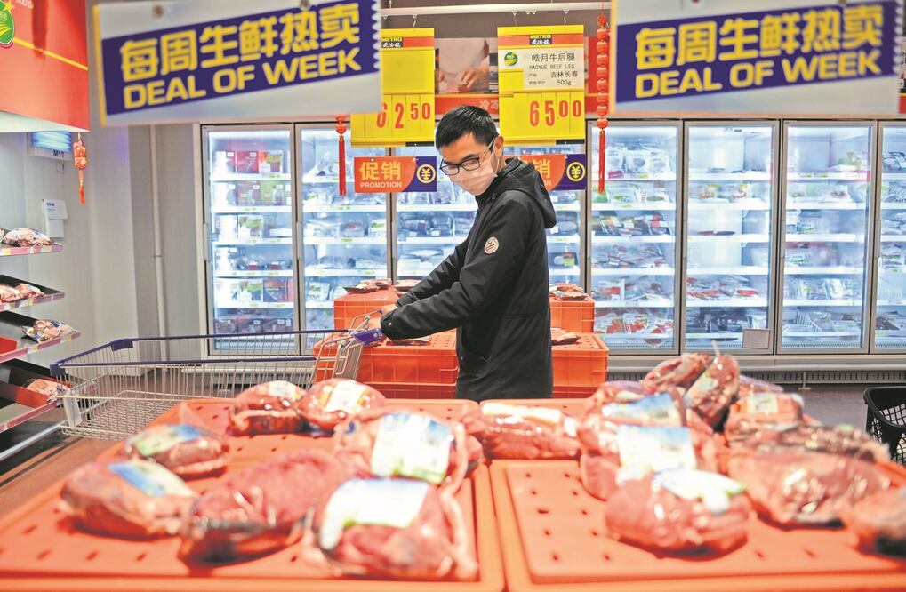 Hombre selecciona carne en un supermercado en Changsha. Foto: Xinhua
