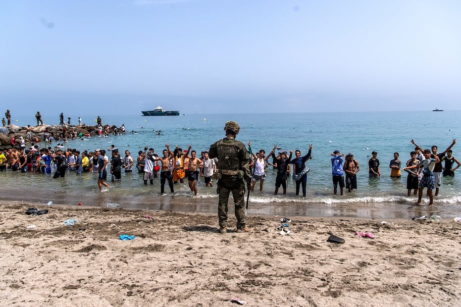 Soldados del ejército español bloquean el acceso a la playa a las personas que cruzan desde Marruecos hacia el enclave español de Ceuta. Foto: AP