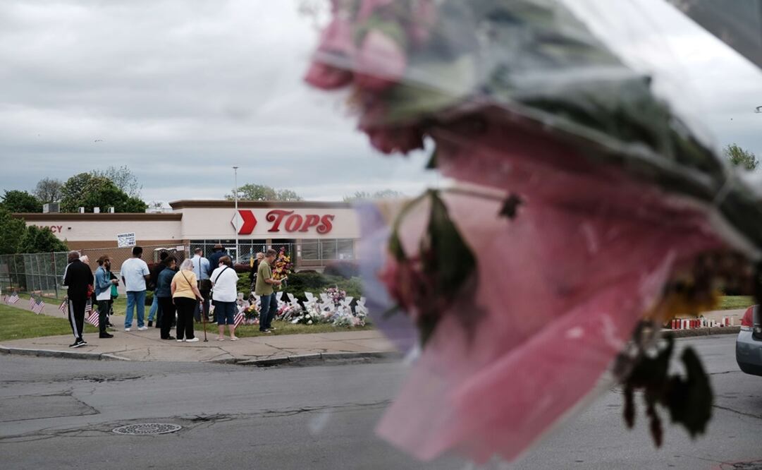 La gente se reúne en un monumento a las víctimas del tiroteo fuera de la tienda de comestibles Tops. Foto: AFP