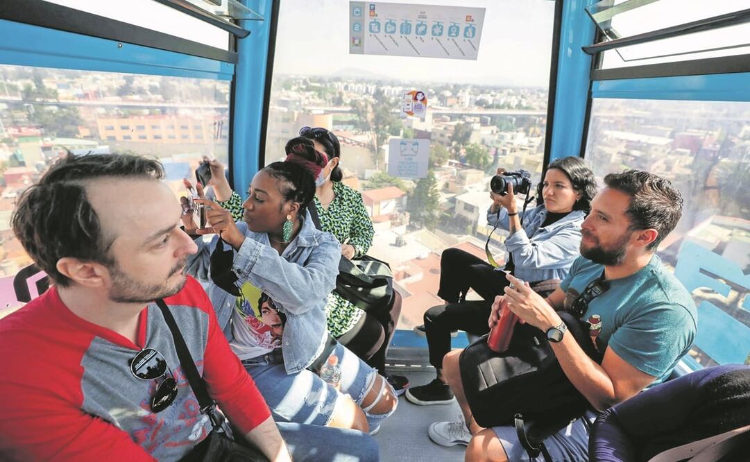 Los turistas toman fotografías de los murales que se aprecian desde el Cablebús. Foto: ESPECIAL