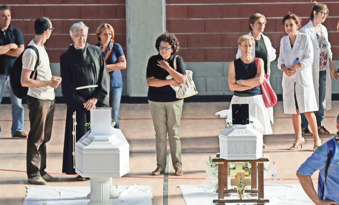 Féretros con los cuerpos de niños muertos en el terremoto fueron colocados ayer en un gimnasio en la provincia italiana de Ascoli Piceno (GREGORIO BORGIA. AP)