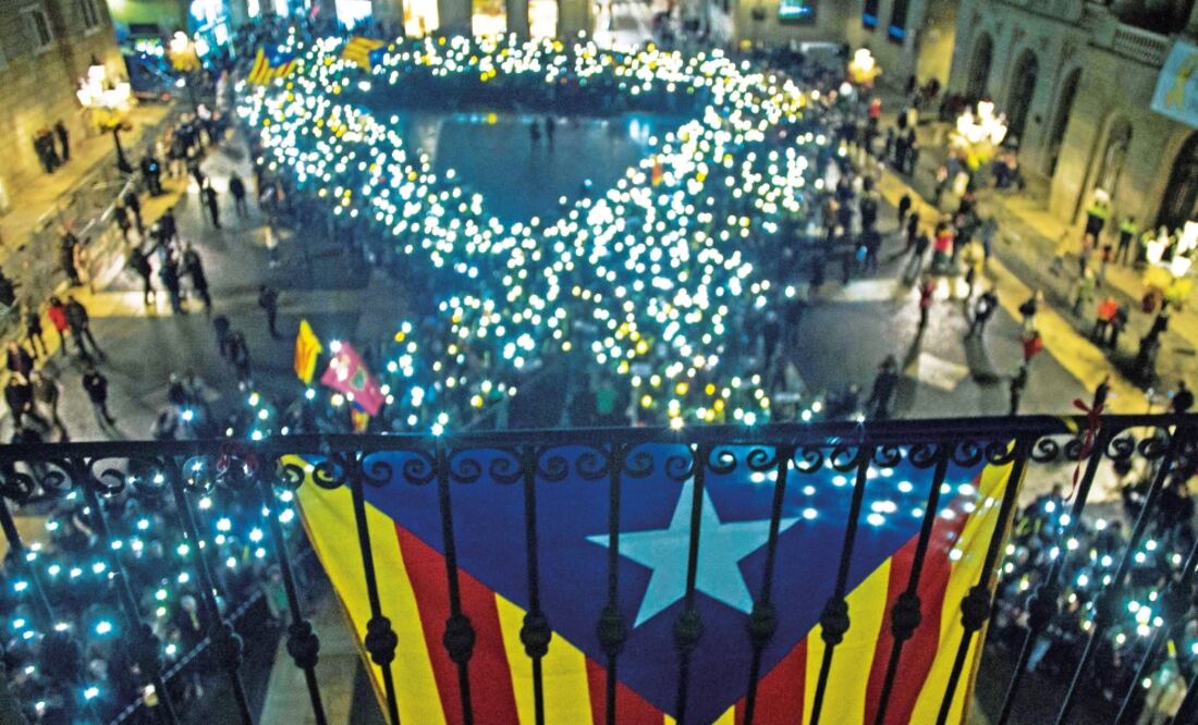 Activistas proindependencia exigieron ayer la liberación de los líderes cata l a n es detenidos y formaron con velas un moño simbolizando la paz. (QUIQUE GARCÍA. EFE)