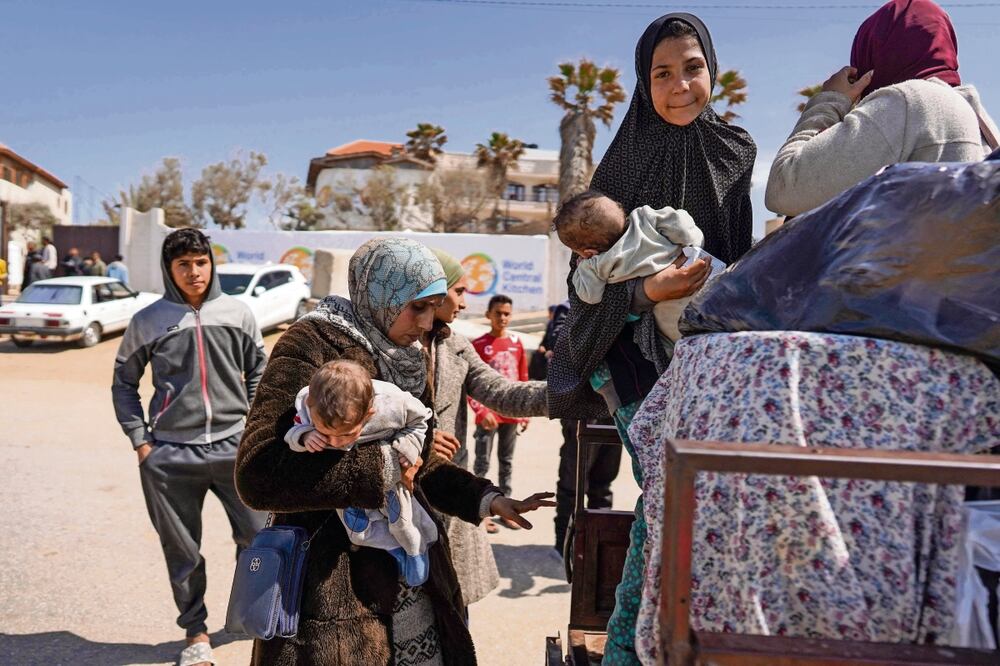 Personas que huyeron del hospital Al-Shifa y sus alrededores, en la ciudad de Gaza, al subir a un vehículo que los conducirá desde el centro de la Franja hacia más al sur. Foto: AFP