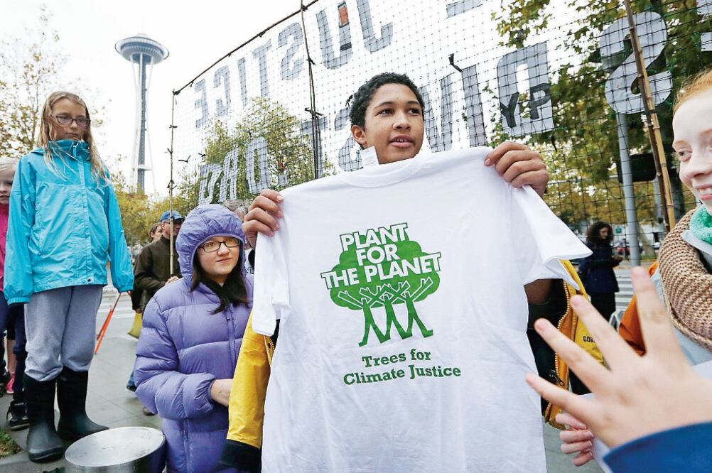 Jóvenes activistas muestran una camiseta con un mensaje pro ambiental después de un mitin reciente en la ciudad de Seattle, en Washington (ELAINE THOMPSON. AP)