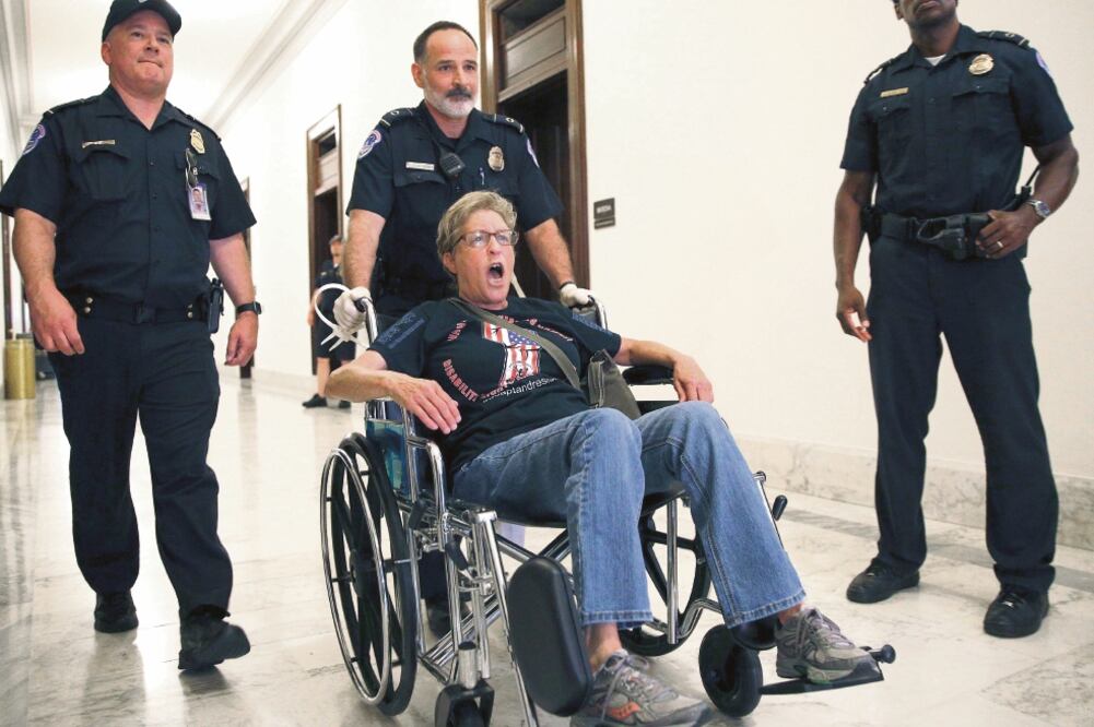 La policía se lleva a un manifestante, luego de una protesta afuera de la oficina del senador Mitch McConnell, uno de los proponentes de la ley de salud (KEVIN LAMARQUE. REUTERS)
