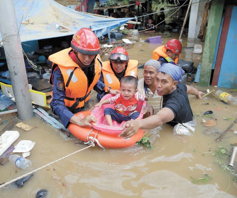Ayuda. Los rescatistas sacan a un niño y a otras personas de una zona inundada en la ciudad de Yakarta. MAST IRHAM. EFE