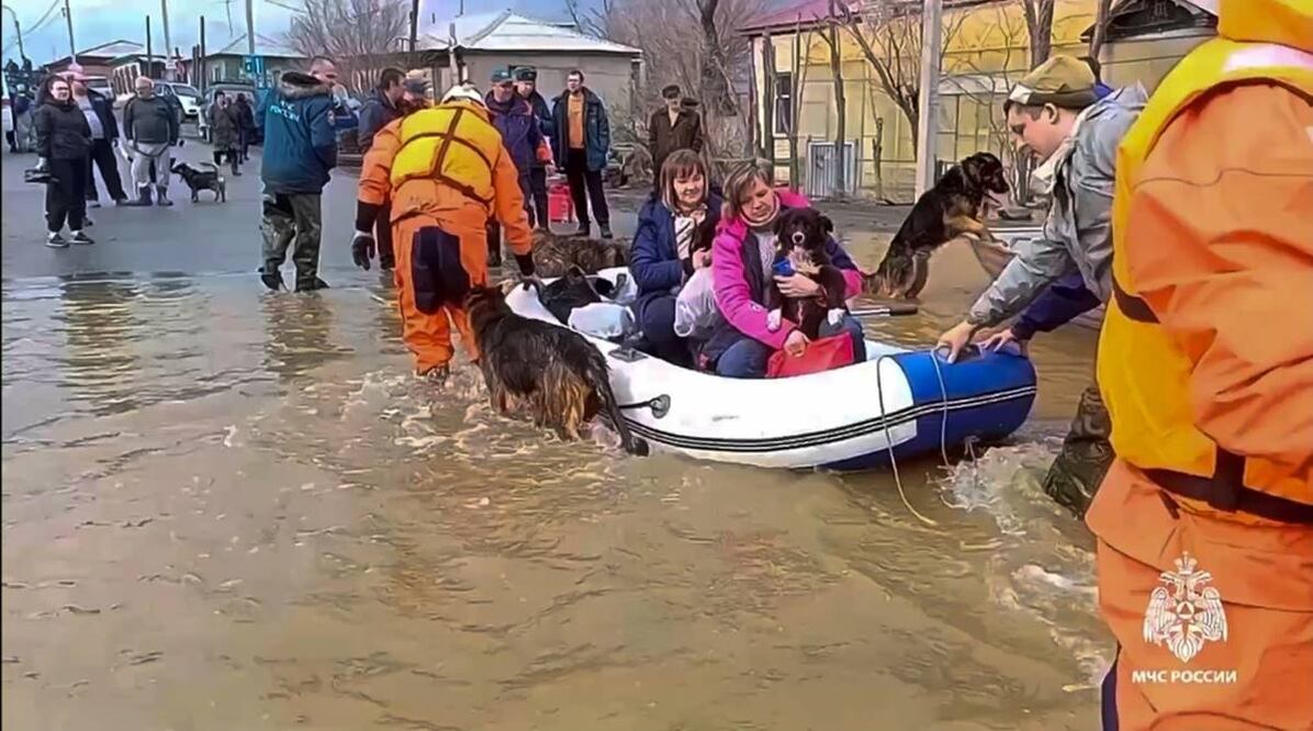 Trabajadores de emergencias evacúan a residentes locales y sus mascotas después de que parte de una represa se rompiera y provocara inundaciones, en Orsk, Rusia. Foto: AP
