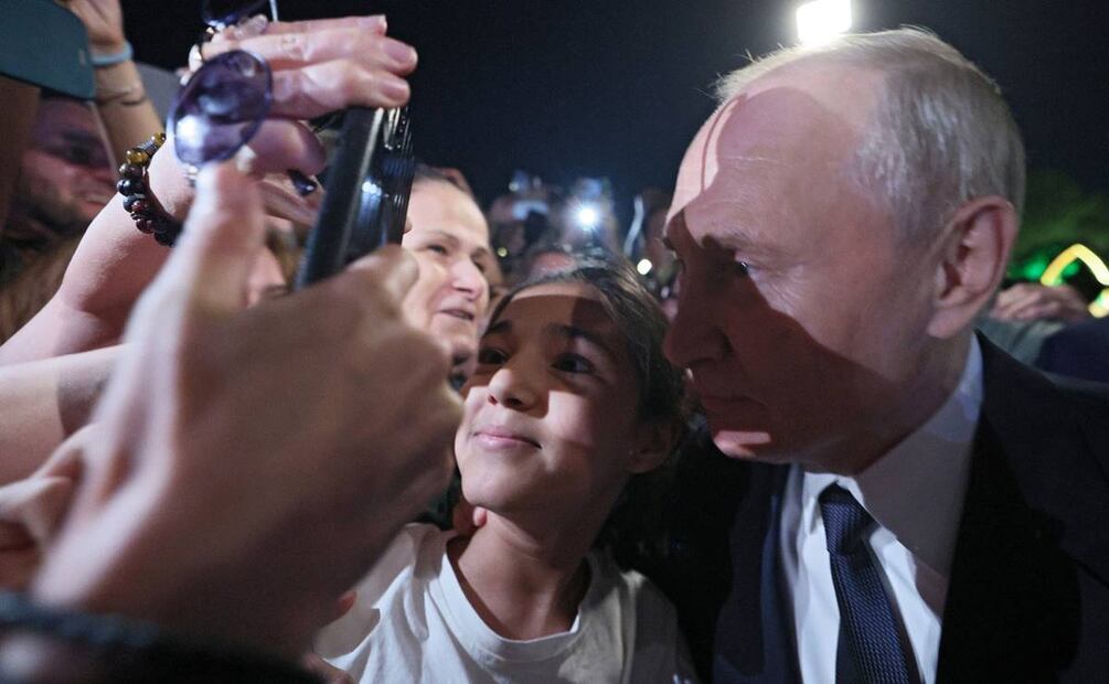 El presidente ruso, Vladimir Putin, aceptó posar para hacerse fotografiar, dio apretones de manos e incluso besó en la cabeza a una niña. Foto: AP
