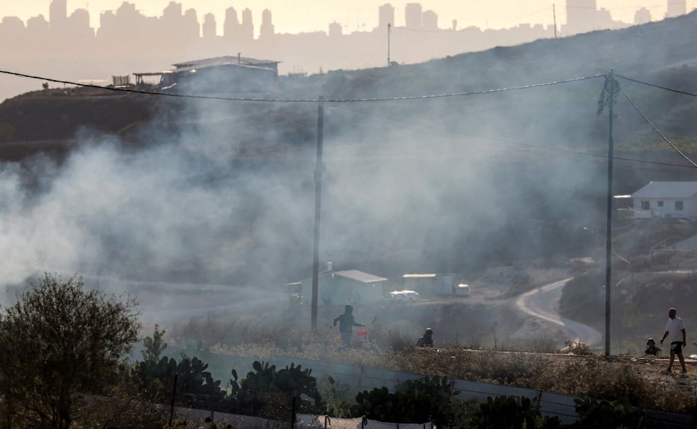 Nubes de gas lacrimógeno cubren la aldea de Tell durante enfrentamientos entre colonos israelíes y palestinos en la Cisjordania ocupada (25/07/2026). Foto: AFP