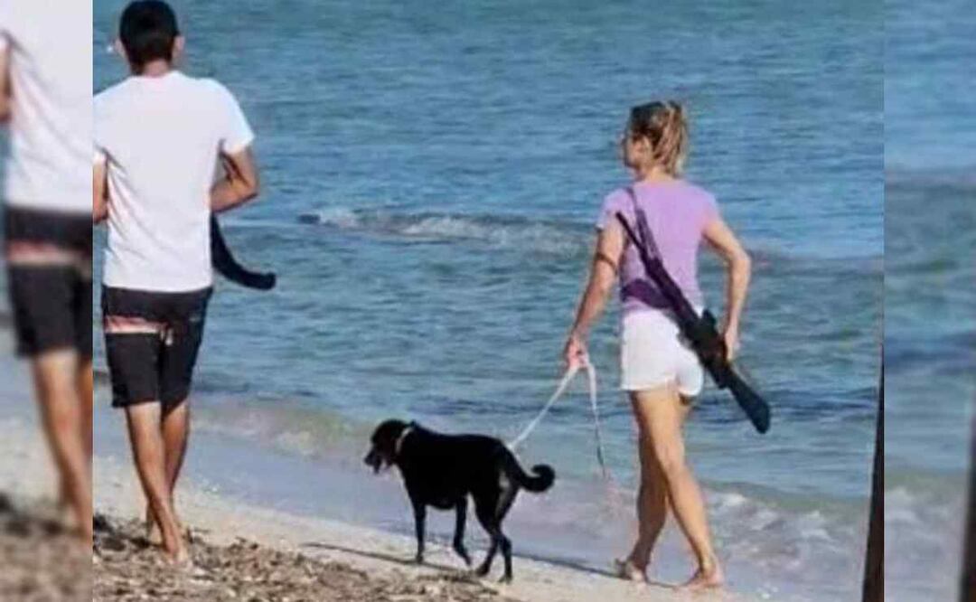 La mujer extranjera caminando por la playa con un rifle. Foto: captura de pantalla