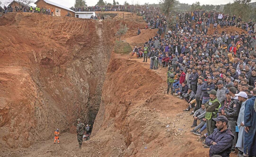 Los equipos de emergencia, luego de sacar el cuerpo del menor de cinco años, en el pueblo de Ighran, en la provincia marroquí de Chefchaouen. Foto: AFP.