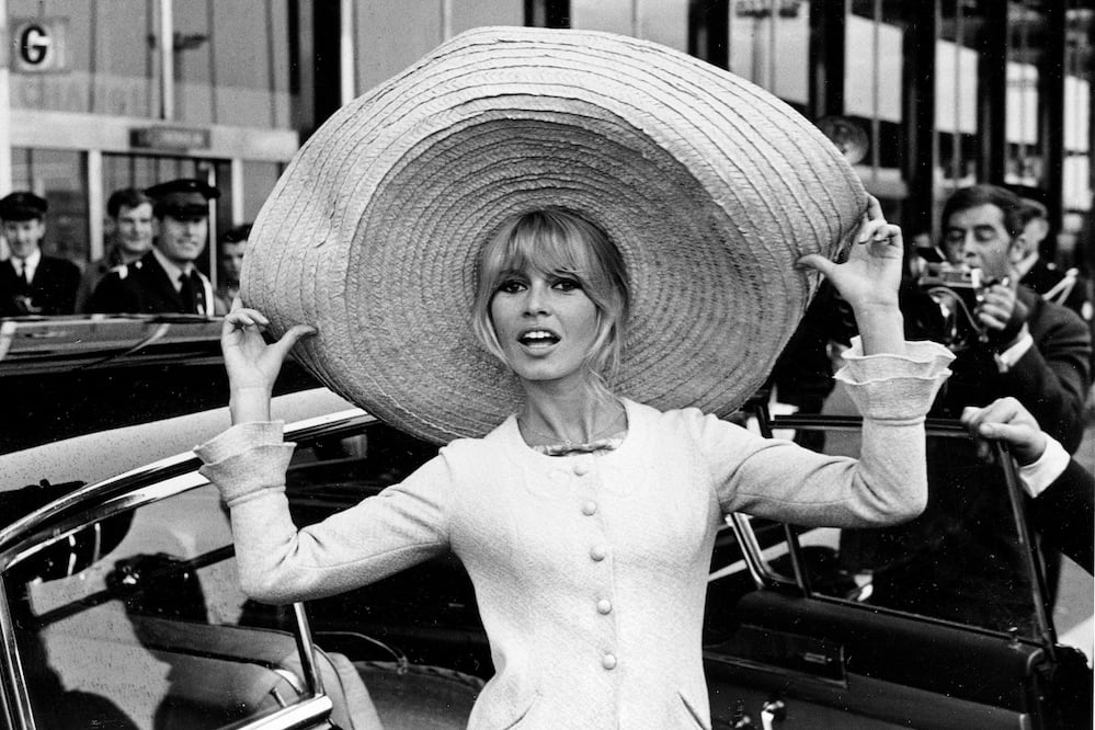 La actriz francesa Brigitte Bardot posa con un enorme sombrero que trajo de México, a su llegada al aeropuerto de Orly, el 27 de mayo de 1965, en París, Francia. FOTO: AP