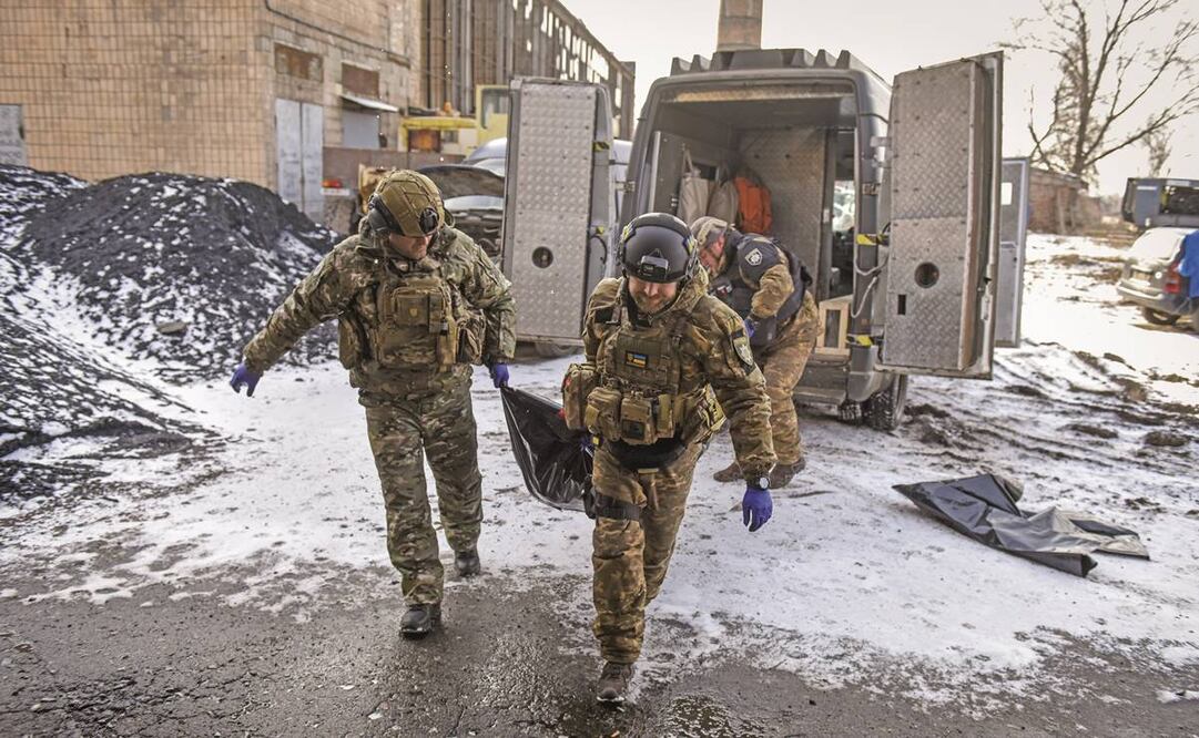 Integrantes de una unidad policiaca, con restos de una persona fallecida en un bombardeo en Bakhmut. Foto: Oleg Petrasyuk/EFE